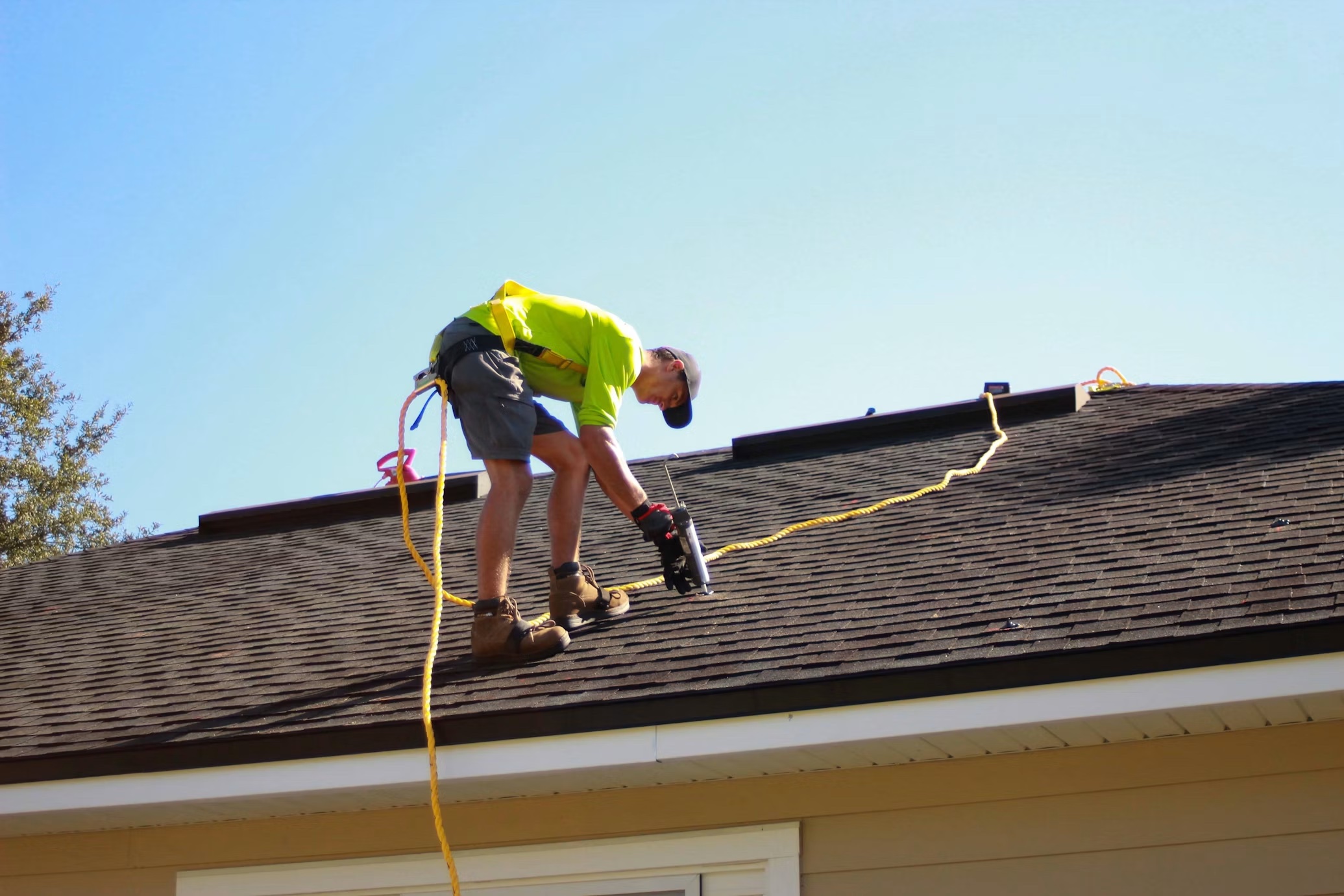 Roofer securing shingles on a residential roof